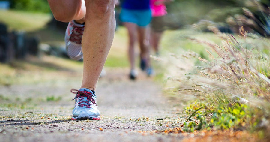 Legs of people running on trail