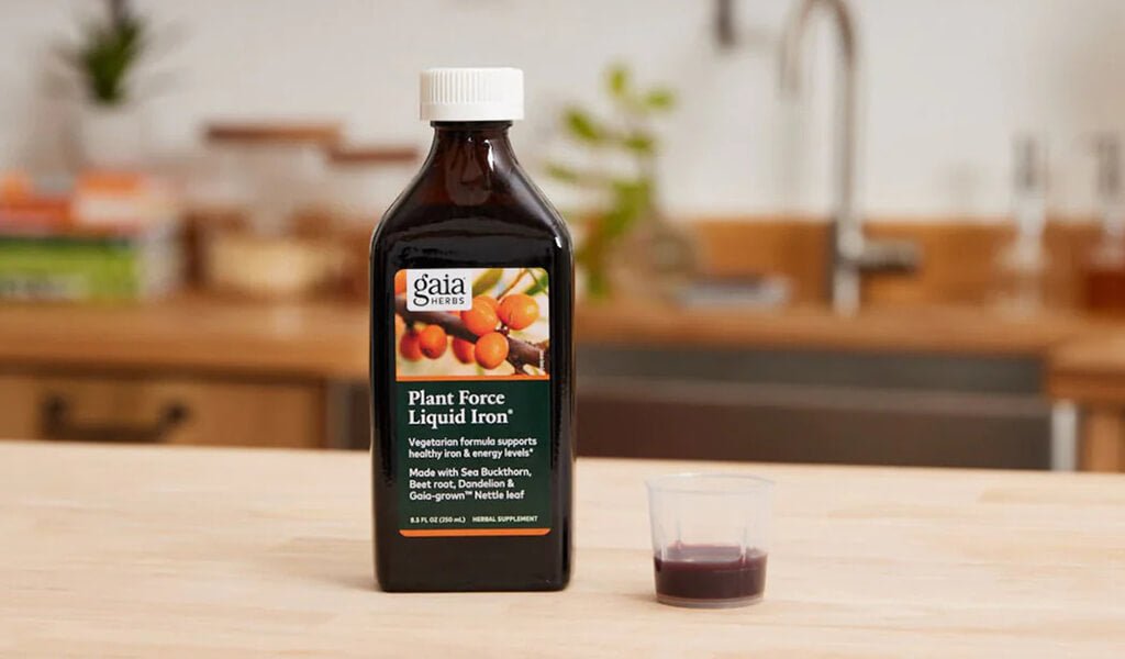 Gaia Herbs PlantForce Liquid Iron next to flowers
