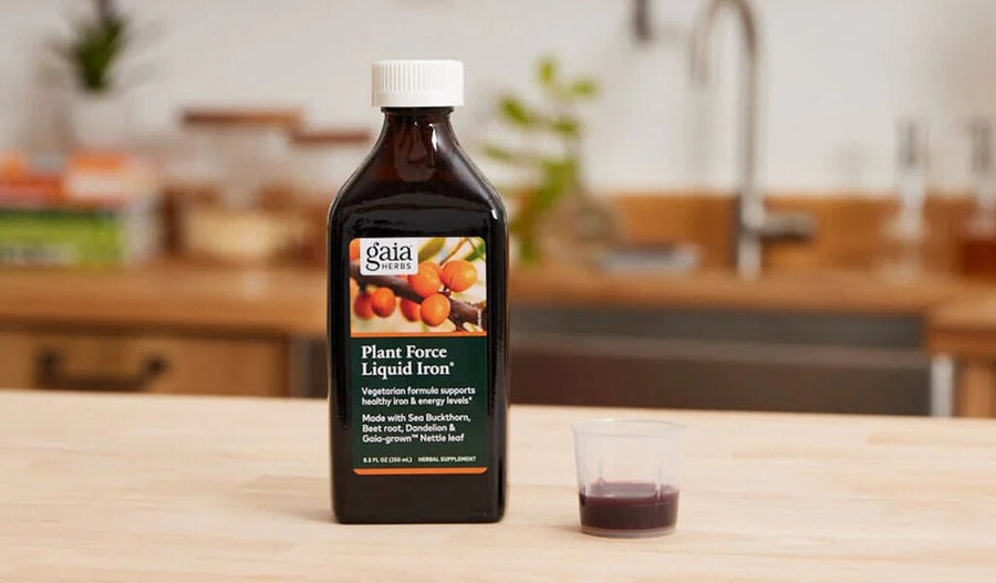 Gaia Herbs PlantForce Liquid Iron next to flowers