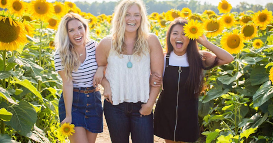 Three woman have emotional health day in sunflower fields