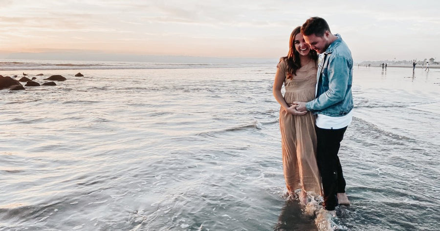 Couple at the beach taking maternity pictures 