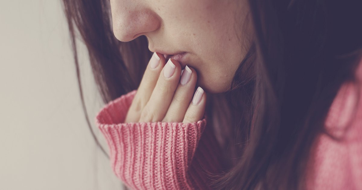 woman holding her hand to her mouth