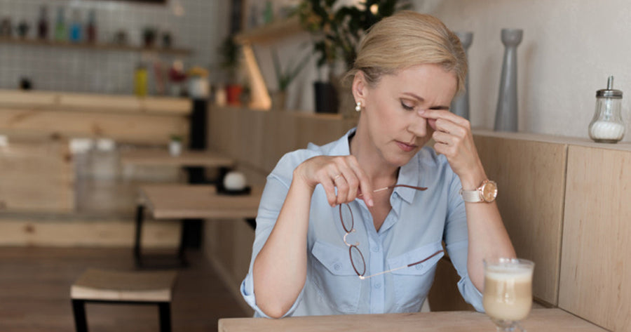 Woman rubbing bridge of nose thinking, 