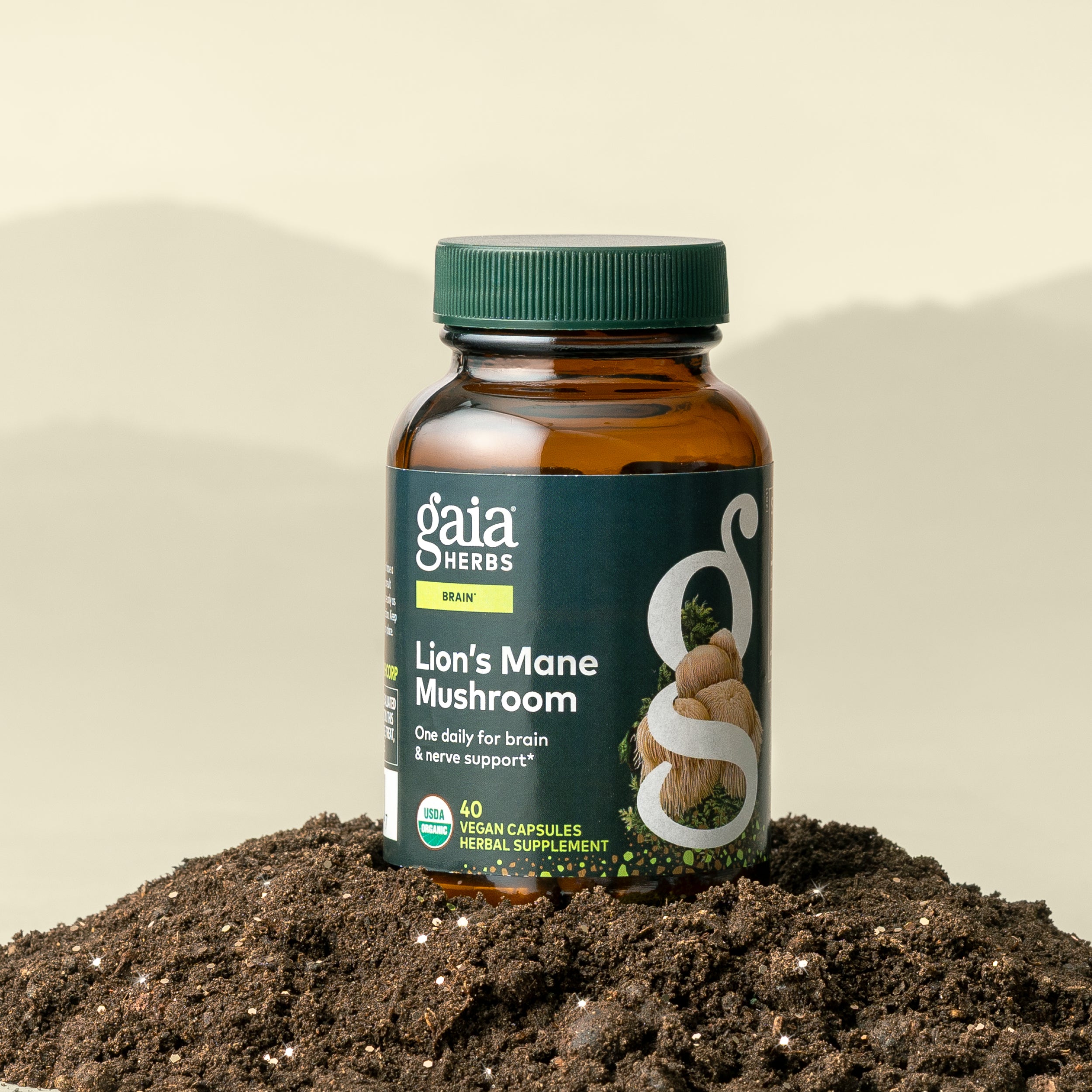 Gaia Herbs Lion's Mane Mushroom supplement bottle on a bed of soil with a beige background
