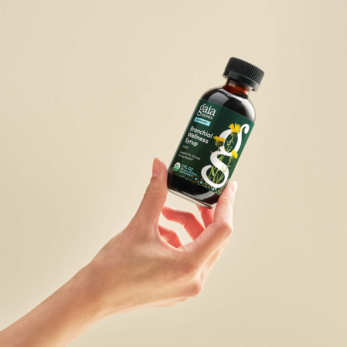 Bronchial Wellness Syrup Kids 3 ounce in a person's hand