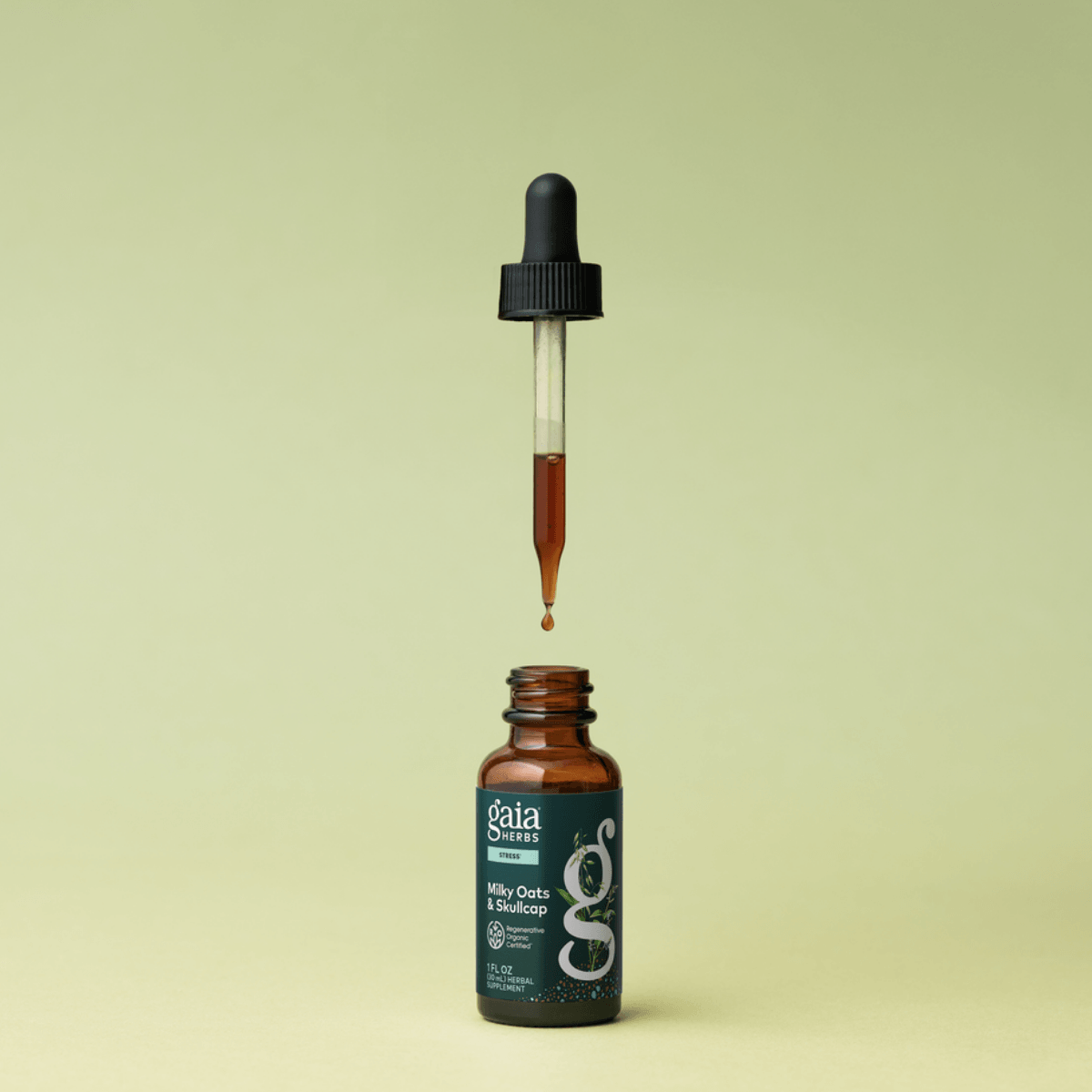 Gaia Herbs Milky Oats & Skullcap dropper bottle with a drop of liquid on a light green background