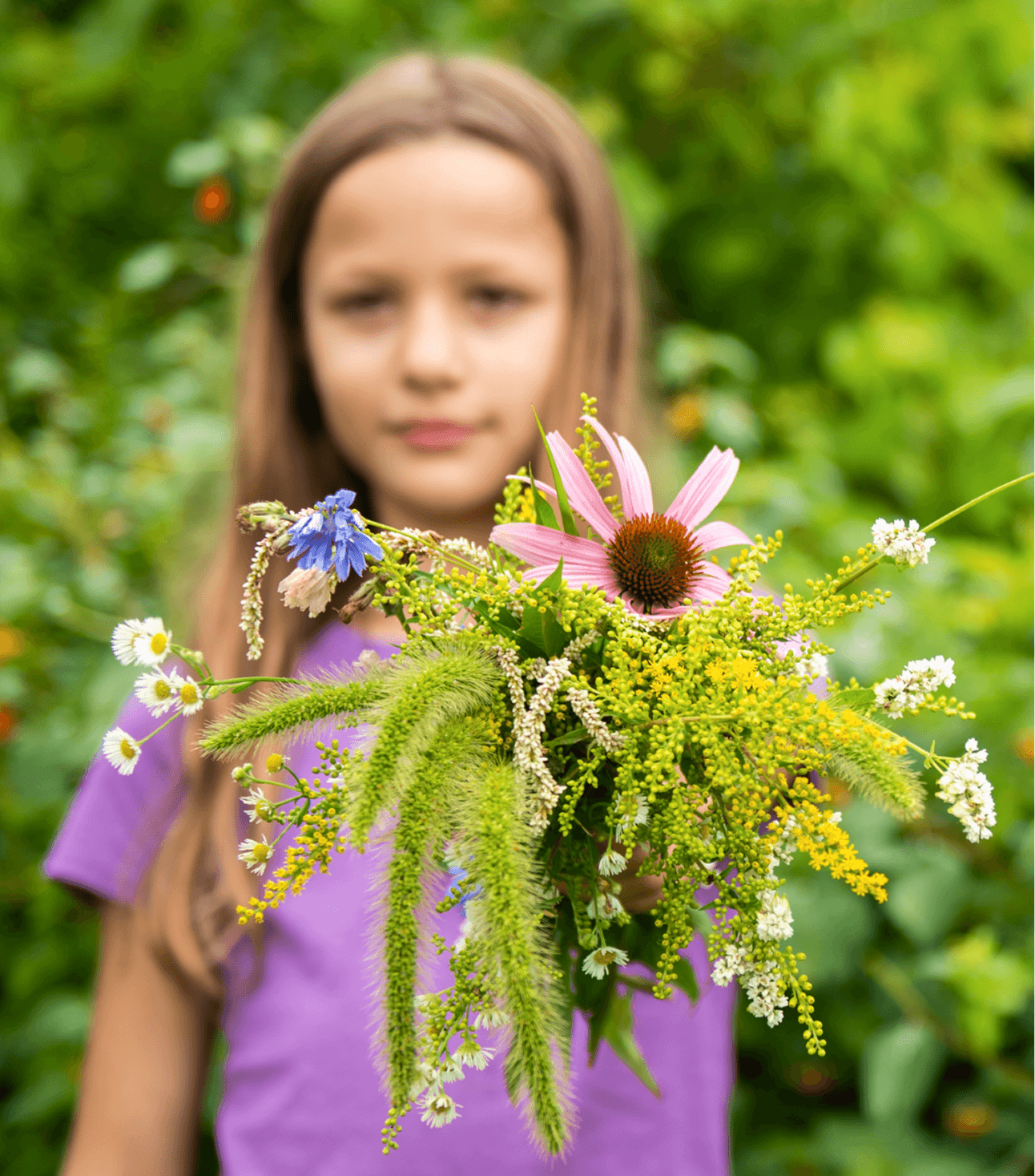 Girl holding a bouquet of wildflowers against a green background