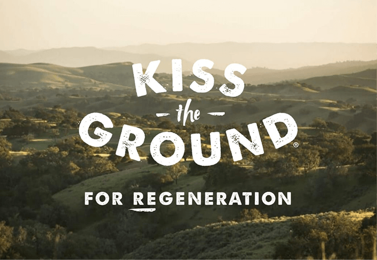 Hilly landscape with 'Kiss the Ground' text overlay