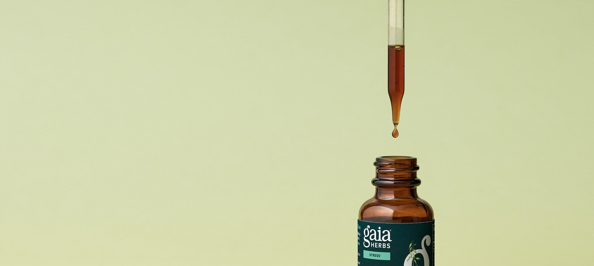 Gaia Herbs dropper bottle with a droplet on a beige background